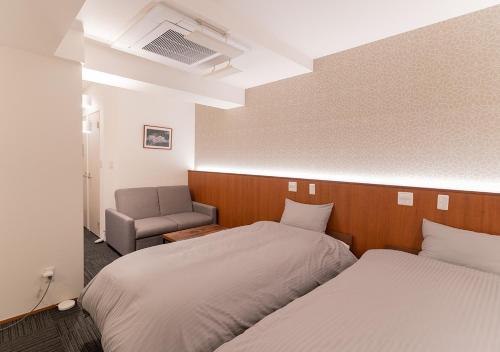 東京的住宿－COCOSHUKU Nakano，酒店客房,配有两张床和椅子