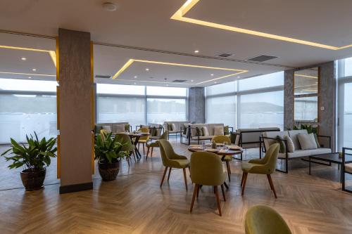 a restaurant with tables and chairs and windows at Shabran Wellbeing Resort in Pirǝbǝdil