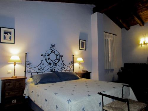 a bedroom with a large bed and two lamps at Hotel Albarrán in Albarracín
