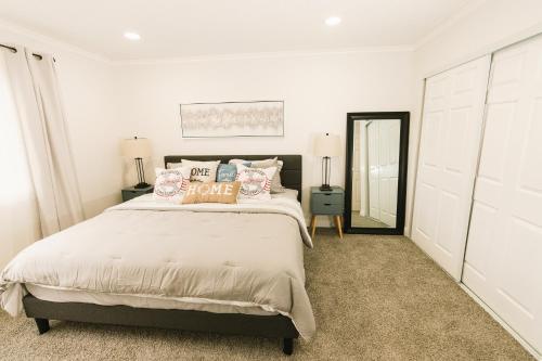a white bedroom with a bed and a mirror at Luxury Sport & Gym Vacation House 10 Guests 5BR 2000sqft in San Jose