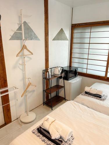a bedroom with two beds and a tv in it at Kikusui Ryokan in Tamano