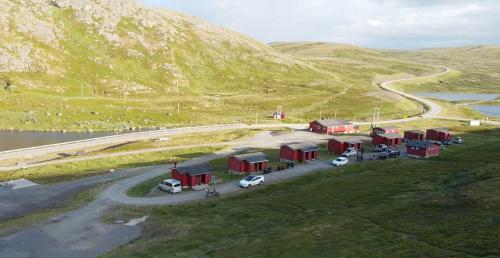 un grupo de coches estacionados frente a un edificio en una carretera en Hytte Camp Nordkapp - Red en Skarsvåg