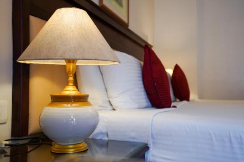 a lamp on a glass table next to a bed at Hotel Arches in Cochin