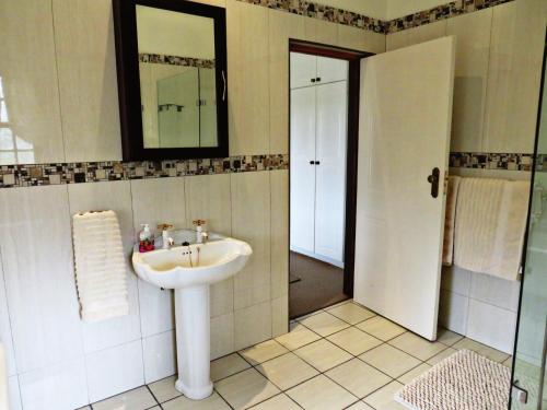 La salle de bains est pourvue d'un lavabo et d'un miroir. dans l'établissement Trumpetters Drift Game Farm, à Grahamstown