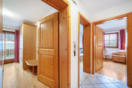a room with wooden doors and a bedroom at Rieglhof Apartment Maisel in Caprone