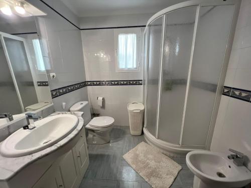 a bathroom with a shower and two toilets and a sink at HABITACIÓN con baño uso privado CENTRO Málaga. in Málaga