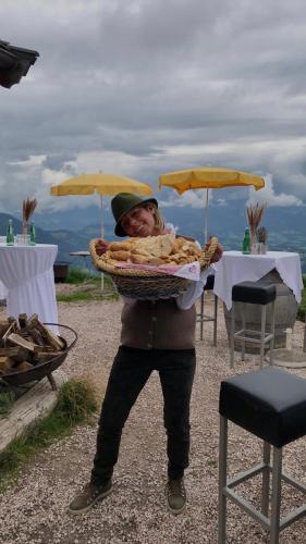 a person holding a basket of food at Hocheckhuette On Top of the Kitzbuehel Hahnenkamm Mountain in Kitzbühel