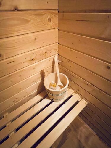 a wooden sauna with a bucket in the corner at Ferienhaus Granula in Linthal