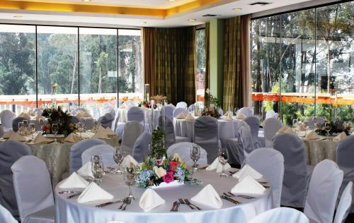 a banquet hall with white tables and white chairs at Oro Verde Cuenca in Cuenca