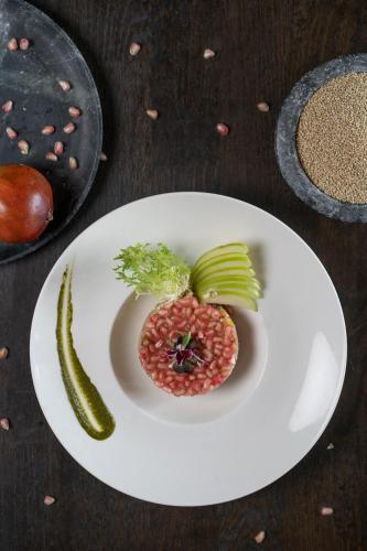 a plate of food with a pomegranate and a pickle at Feathers- A Radha Hotel, Chennai in Chennai