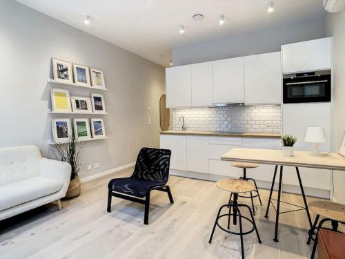 a kitchen with white cabinets and a table and chairs at Nieuw appartement in Leuven centrum! in Leuven