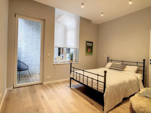 a bedroom with a bed and a large window at Nieuw appartement in Leuven centrum! in Leuven