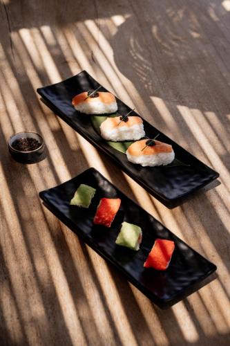 two black plates of food on a table at Irida Hotel Agia Pelagia in Agia Pelagia