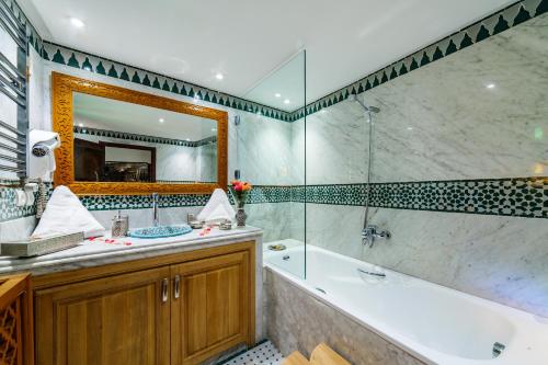 a bathroom with a tub and a sink and a tub and a mirror at Riad Rcif & Spa Originale in Fès