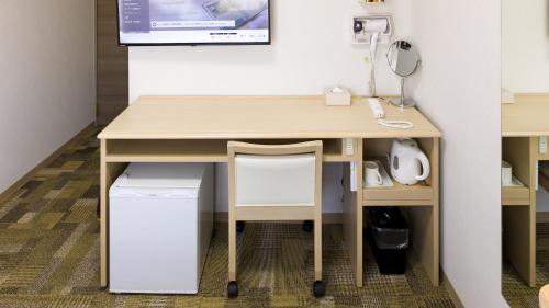 a wooden desk with a chair next to a table at Toyoko Inn Kyoto Nijojo Minami in Kyoto