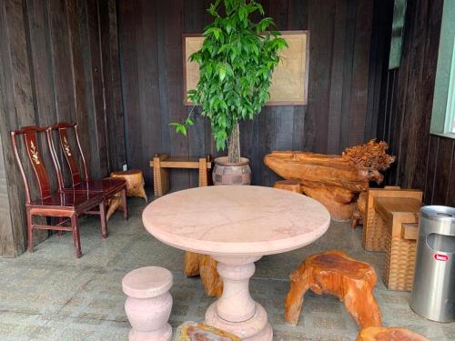 a table and chairs and a potted plant in a room at MCITI Suites in Miri