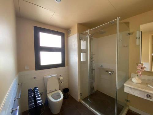 a bathroom with a toilet and a shower and a sink at Cove private one bedroom lagoon villa in Ras al Khaimah