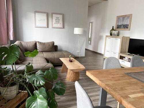 ein Wohnzimmer mit einem Sofa und einem Tisch in der Unterkunft Weinquartier Naumburg in Naumburg