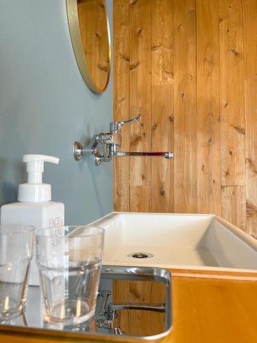 a bathroom sink with glasses on a counter at Kikusui Ryokan in Tamano