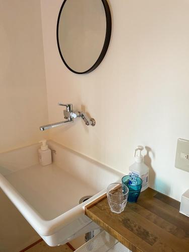 a bathroom with a sink and a mirror on the wall at Kikusui Ryokan in Tamano