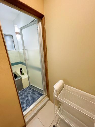 a bathroom with a shower with a mirror at Kikusui Ryokan in Tamano