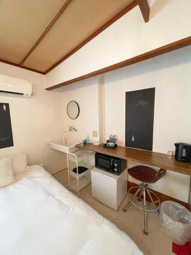 a bedroom with a bed and a desk and a sink at Kikusui Ryokan in Tamano