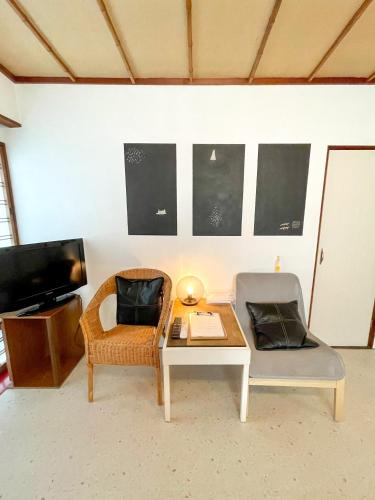 a living room with a table and two chairs at Kikusui Ryokan in Tamano