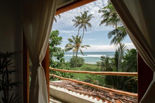 um quarto com uma janela com vista para o oceano em Maria Bonita Sri Lanka em Ahangama