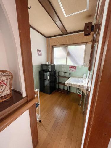 a small room with a table and a kitchen at Kikusui Ryokan in Tamano