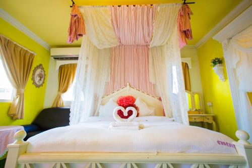 a bedroom with a white bed with a heart on it at 墾丁戀戀莎堡特色民宿 Castillo in Eluan