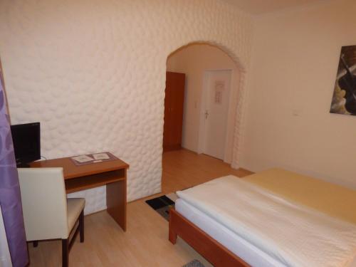 a bedroom with a desk and a bed and a table at Hotel Diele in Detmold