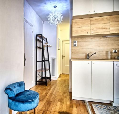 uma cozinha com uma cadeira azul e um lavatório em Loft 4/6 pers proximité centre ville, gare et tram em Caen
