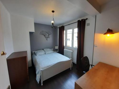 niewielka sypialnia z łóżkiem i oknem w obiekcie Loft 4/6 pers proximité centre ville, gare et tram w Caen