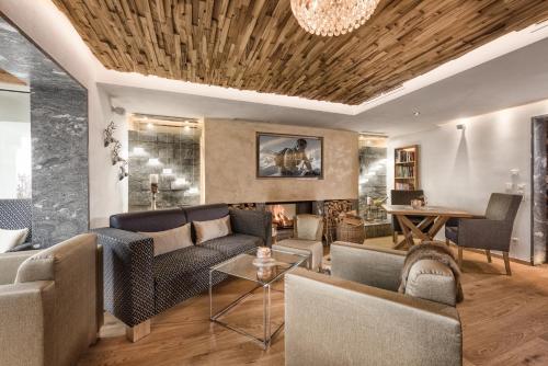 ein Wohnzimmer mit Sofas und einem Kamin in der Unterkunft Alpines Lifestyle Hotel Tannenhof in St. Johann im Pongau