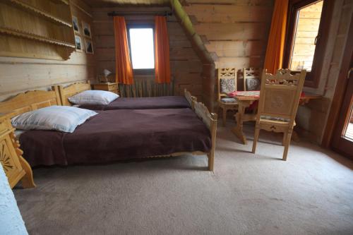 sypialnia z 2 łóżkami w drewnianym domku w obiekcie Szałas pod Szymoszkową w mieście Kościelisko
