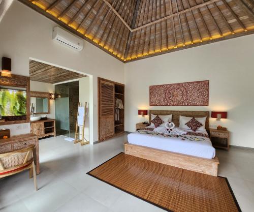 a bedroom with a bed and a desk at Pinggala Villa Ubud in Gianyar