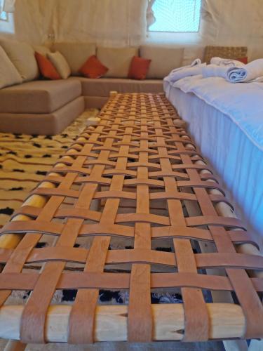 two beds in a room with a couch at CameLuxe Camp in Mhamid