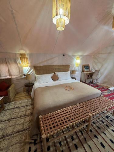a bedroom with a large bed in a tent at CameLuxe Camp in Mhamid