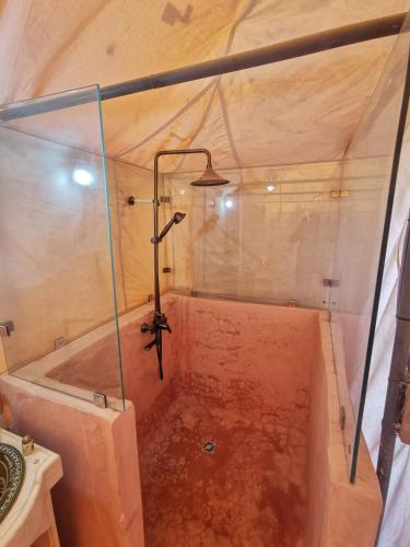 a shower in a tent with a bath tub at CameLuxe Camp in Mhamid