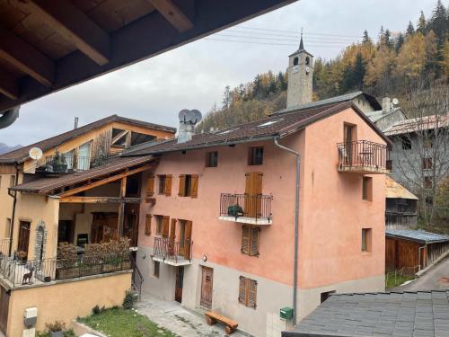 un gran edificio rosa con balcones y una torre en Suite Yellowstone en Peisey-Nancroix