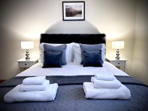 a bedroom with a large bed with towels on it at Lomond Castle Penthouse in Luss
