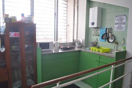 a green kitchen with a counter and a microwave at Arcanjo Hostel 2 in Braga