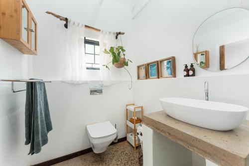 a bathroom with a white sink and a toilet at Dolphin Coast Doll House - quaint cottage close to the beach! in Salt Rock