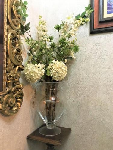 a vase with flowers on a shelf next to a mirror at La Casa dels Poetes in Santa Pau