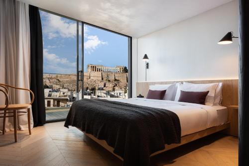 a bedroom with a large bed and a large window at Urban Stripes Athens in Athens
