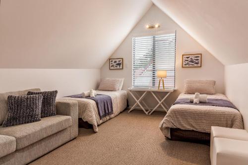 a attic room with two beds and a couch at Bluewater Bungalow in Dunsborough
