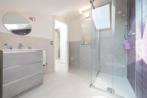un bagno con doccia, lavandino e specchio di Casa Viola Lazise lago e relax! a Lazise