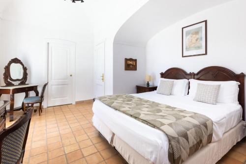 a bedroom with a bed and a table and a desk at Oasi Olimpia Relais in SantʼAgata sui Due Golfi