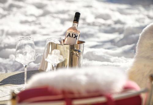 a bottle of wine in a bucket on a table with glasses at Alpines Lifestyle Hotel Tannenhof in Sankt Johann im Pongau