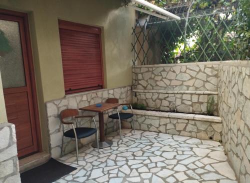 a patio with a table and chairs next to a building at Casa D' Irene in Karpenisi